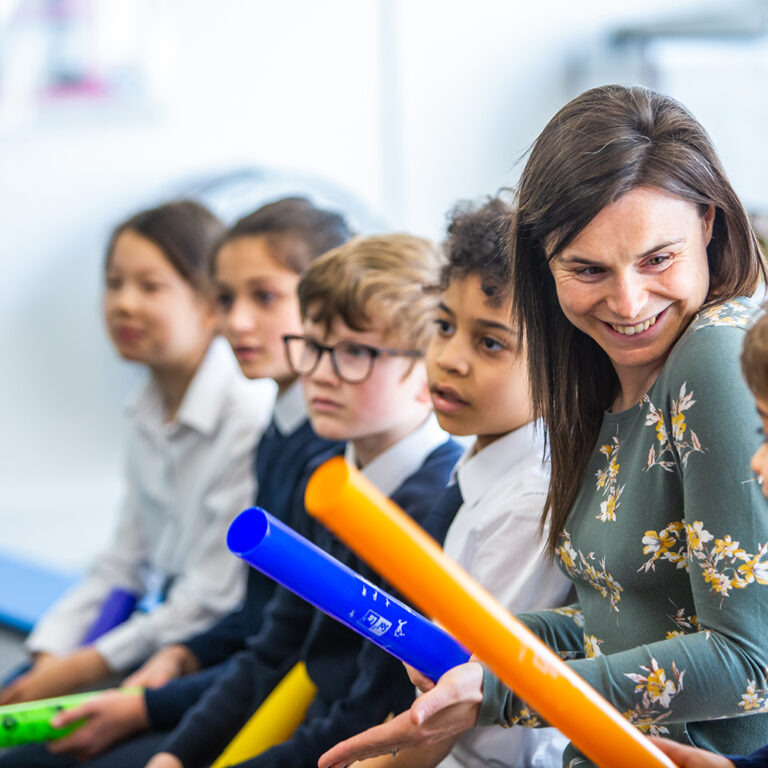 teacher and her students holding batons