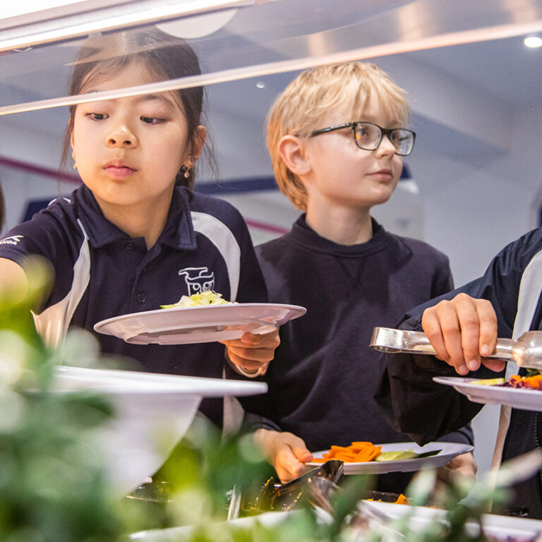students grabbing salad and vegetables from the cafeteria