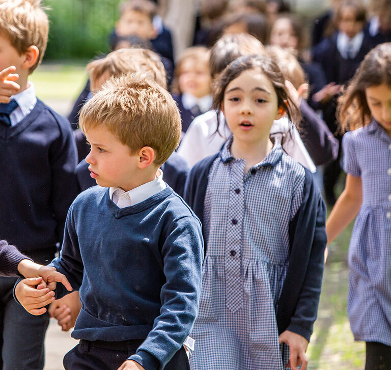 students walking into school holding hands