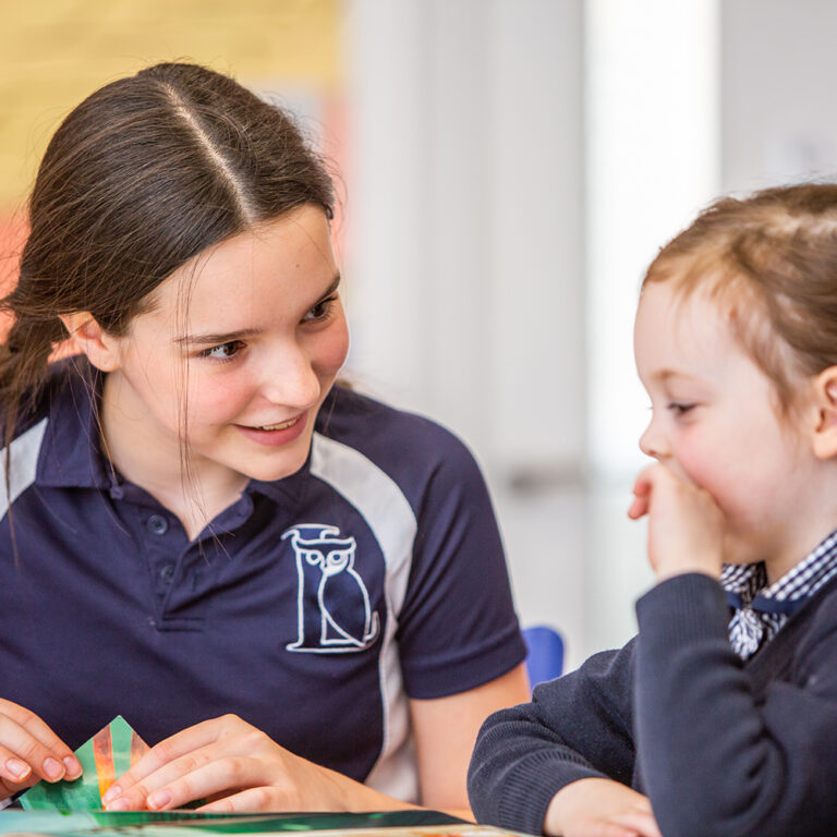 2 students reading a book together