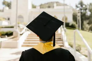 A boy wearing the graduate hat looking at the university